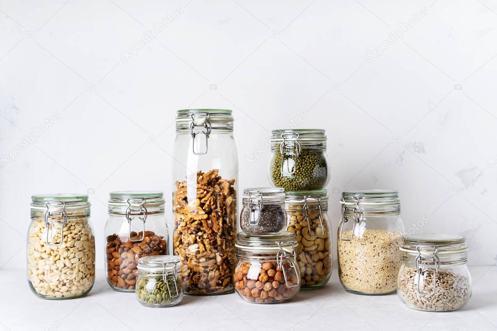 Collection of almonds, cashews, peanuts, hazelnuts, walnuts and Chia seeds, mung beans, quinoa, sunflower seeds in glass jars