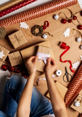 Bant, ip, kağıt ambalaj üzerinde kağıt rulo ve süslemeleri sahne ambalaj ile hediye kutusu kaydırma eller üstten görünüm