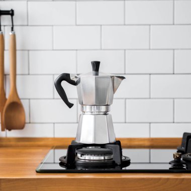 Beyaz çini ve spatula arka plan üzerinde duvara gümüş Moka kahve pot gaz sobası