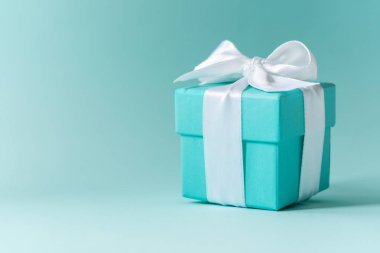 Tiffany mavi renk kutusunu pastel arka plan üzerinde beyaz ipek kurdele ile bağlı 
