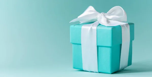 Tiffany mavi renk kutusunu pastel arka plan üzerinde beyaz ipek kurdele ile bağlı 