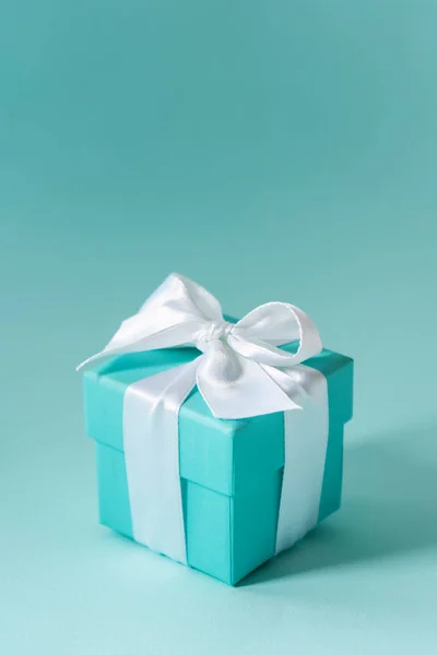 Tiffany blue color box tied with white silk ribbon on pastel background