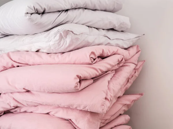 可以看到一堆白色和柔和的粉红色床上用品枕头和毯子 — 图库照片