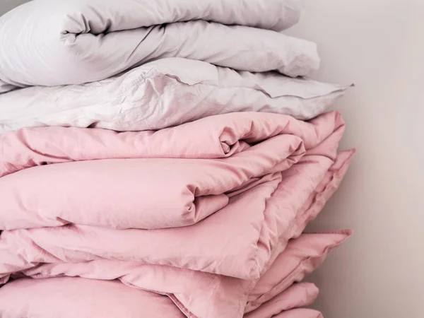 Beyaz ve pastel pembe çarşaf yastık ve battaniye yığın görünümü Kapat