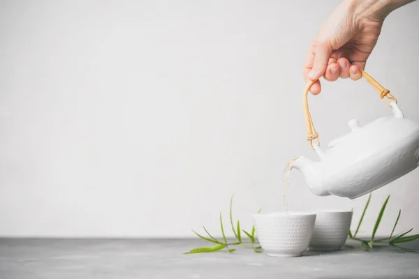 女性手将绿茶从茶壶倒进杯中 背景为白色背景 并有复制空间 亚洲茶具 — 图库照片