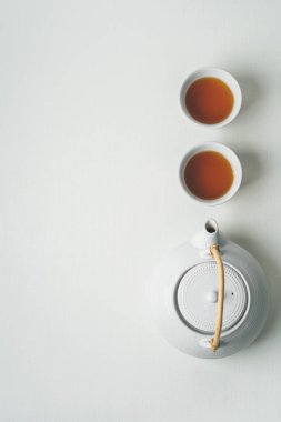 Asya minimalist çay kavramı, iki bardak çay demlik bir vizyon ve yukarıdan, bir metin için yer üzerinde beyaz kumaş arka plan beyaz.