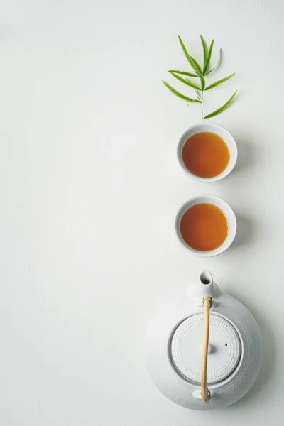 Tazas Blancas Tetera Rodeadas Hojas Bambú Verde Sobre Fondo Blanco —  Fotos de Stock