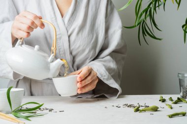 Erkek dökme çay çaydanlık çay fincanı seçici odak için eller. Bira ve çay içme.