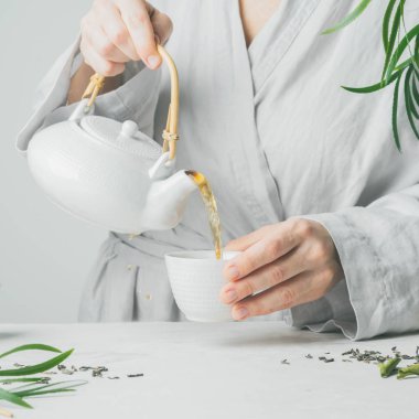 Erkek dökme çay çaydanlık çay fincanı seçici odak için eller. Bira ve çay içme.