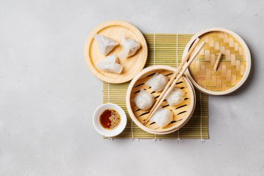 Geleneksel Çince köfte sosu ve yemek çubukları ile bambu vapur Dim toplamların üzerinde açık renkli buğulama 