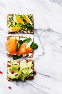 protein tost lezzetli soslar somon balığı, yumurta ve salatalık mermer yüzeyi ile