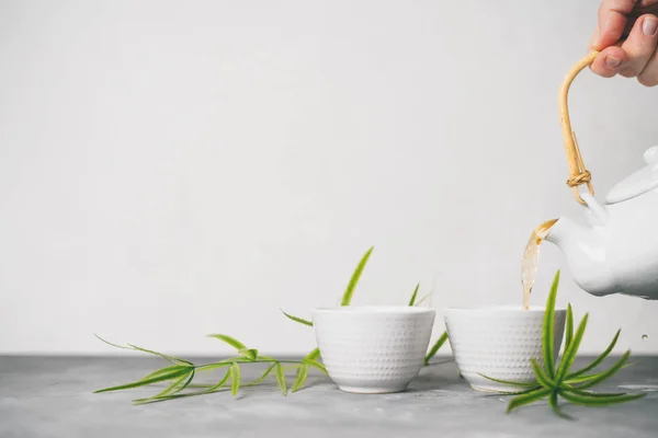 女性手将绿茶从茶壶倒进杯中 背景为白色背景 并有复制空间 亚洲茶具 — 图库照片
