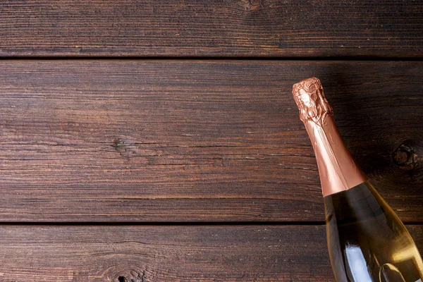 木制背景上的一瓶香槟 — 图库照片