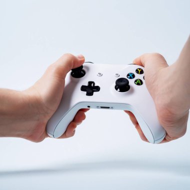Erkek beyaz arka plan üzerinde beyaz gamepad oyun çubuğu tutan eller