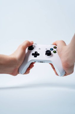 Erkek beyaz arka plan üzerinde beyaz gamepad oyun çubuğu tutan eller