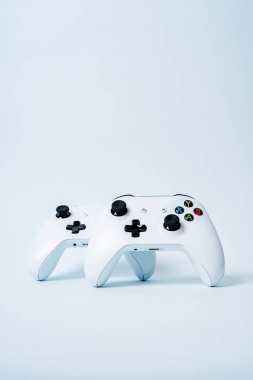 Kopya alanı pastel mavi zemin üzerine gamepads denetleyicisi oyun çubukları