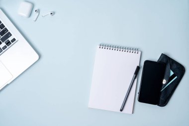 laptop, akıllı telefon, kablosuz kulaklık, defter, açık mavi renkli kredi kartı ile cüzdan ile kompozisyon