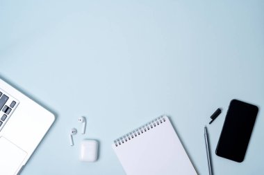dizüstü bilgisayar, telefon, kablosuz kulaklık, açık mavi renkli üstünde not etmek ile kompozisyon
