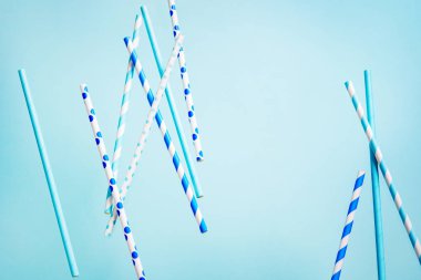 Pastel mavi zemin üzerine içecek için uçan içme payet