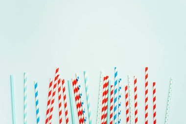 Pastel mavi arka planda içecek için içme pipet yığını