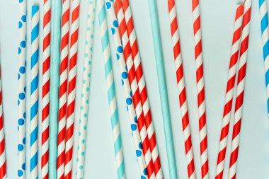 Pastel mavi arka planda içecek için içme pipet yığını