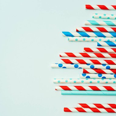 Pastel mavi arka planda içecek için içme pipet yığını