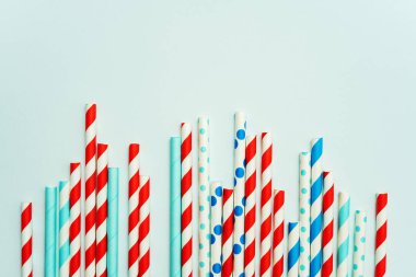 Pastel mavi arka planda içecek için içme pipet yığını