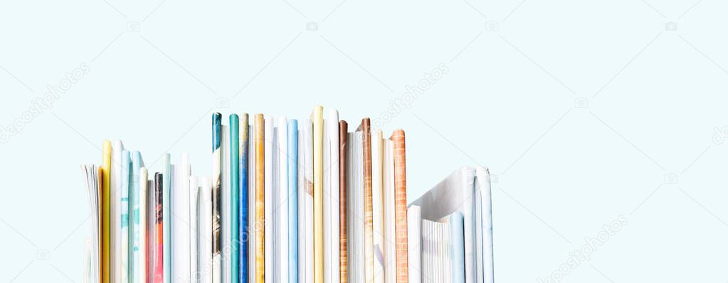 Close view of stack colorful books on pastel blue background
