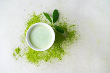 Beton arka plan üzerinde dağınık toz çay üzerinde yaprakları ile süslenmiş Japon Matcha çay bawl ile Kompozisyon