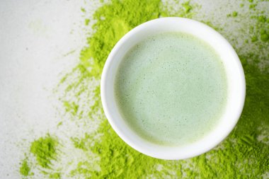 Beton arka plan üzerinde dağınık yeşil toz çay üzerinde Japon Matcha çay ile Bawl