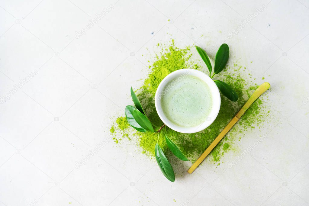 Bowl organic green tea Matcha powder with Chashaku spoon on light background