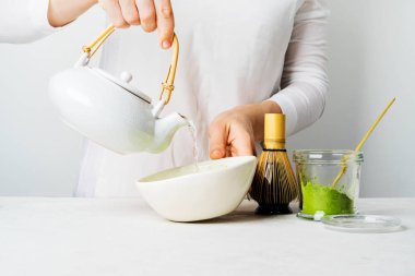 Organik yeşil çay Matcha yapmak için çaydanlık su döken kadının yakın görünümü