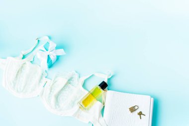 Turkuaz arka plan üzerinde hediye kutusu ile yumuşak dantel sütyen ve parfüm ile zarif şık dantel beyaz set iç çamaşırı