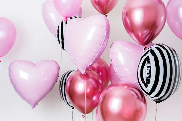 Set of pink and striped balloons in form of heart and round pink and striped on pastel pink background