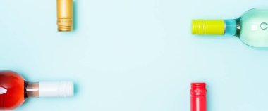 Mavi arka plan üzerinde beyaz ve gül şarap şişeleri Vidaşişe folyo kapaklar