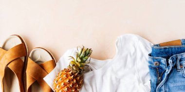 Beyaz t-shirt, kot şort ve pembe pastel arka plan üzerinde ananas ile trendy deri sandalet