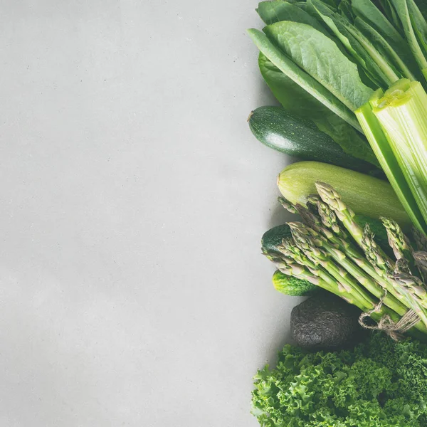 Gri beton arka plan üzerinde taze yeşil sebze ve yeşillik çeşitleri 