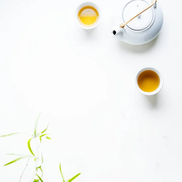 Dos Tazas Blancas Tetera Rodeadas Hojas Verdes Sobre Fondo Blanco —  Fotos de Stock