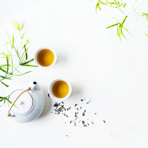 Két Fehér Csésze Tea Teáskanna Körül Zöld Levelek Fehér Háttér — Stock Fotó