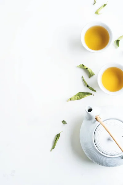 Duas Xícaras Brancas Chá Bule Cercado Com Folhas Verdes Fundo — Fotografia de Stock