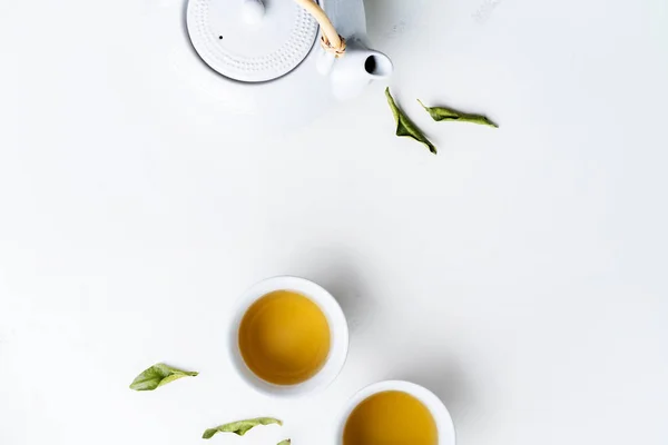 Çay Çaydanlık Iki Beyaz Bardak Beyaz Arka Plan Üzerinde Yeşil — Stok fotoğraf
