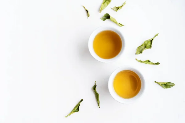 Dva Bílé Šálky Čaje Zelenými Čajovýma Listy Bílém Pozadí — Stock fotografie