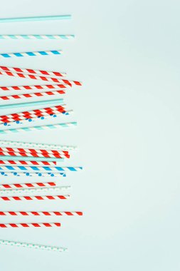 Pastel mavi arka planda içecek için içme pipet yığını