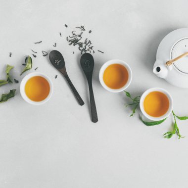 Asya yeşil yaprakları ile beyaz zemin üzerine yeşil çay, bardak ve çaydanlık ayarla 