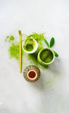 Chasen bambu çırpıcı ile Organik yeşil çay Matcha tozu, hafif arka plan üzerinde demlemek için kase