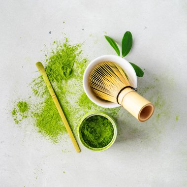 Chasen bambu çırpıcı ile Organik yeşil çay Matcha tozu, hafif arka plan üzerinde demlemek için kase