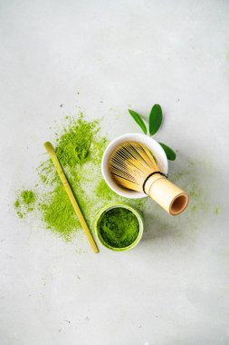 Chasen bambu çırpıcı ile Organik yeşil çay Matcha tozu, hafif arka plan üzerinde demlemek için kase