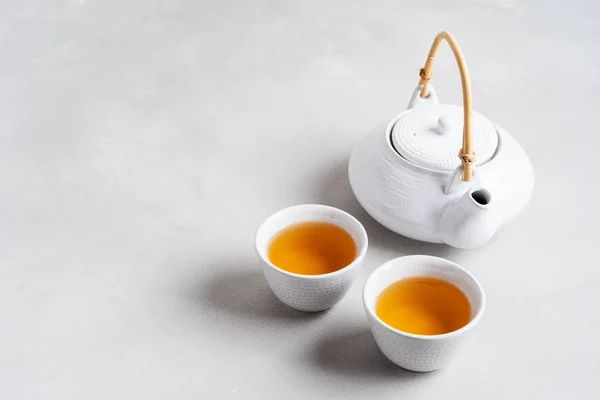 灰色背景上的白茶杯和茶壶 — 图库照片