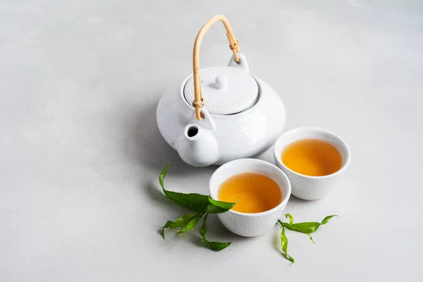 White Cups Tea Teapot Surrounded Green Leaves Grey Background — Stock Photo, Image