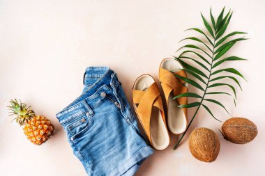 Palmiye yaprağı ile pembe pastel arka plan trendy deri sandalet ve denim şort